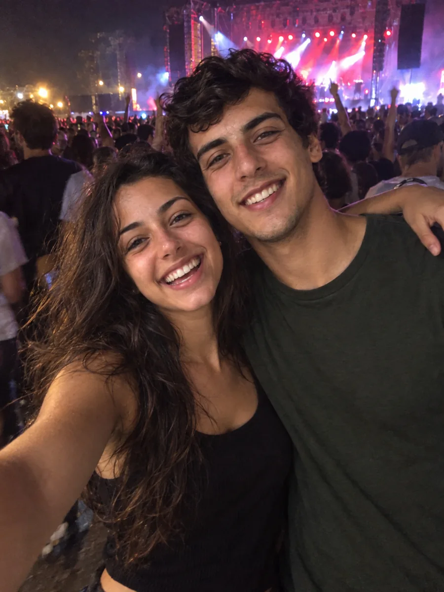 Ana e Lucas abraçados em um show à noite, com o palco iluminado atrás.